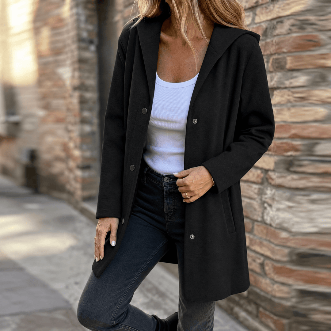 Black hooded longline cardigan jacket with button front and pockets, worn open outdoors
