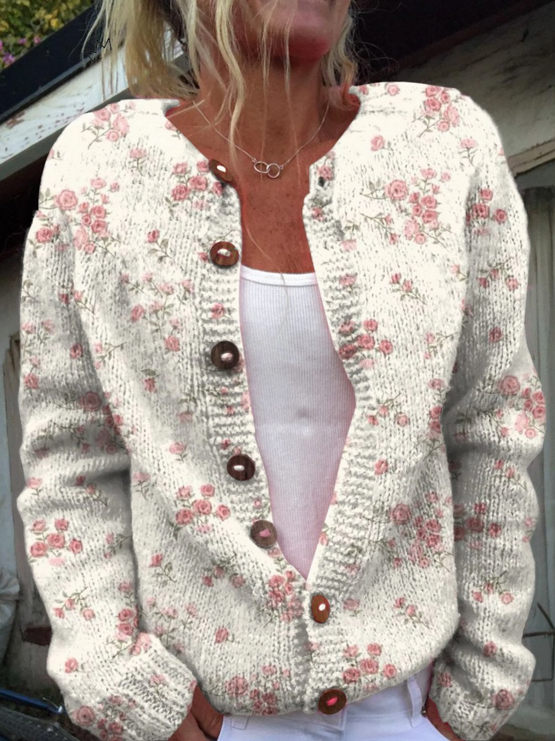 Cream knit cardigan with a small pink rose print and wooden buttons, worn open