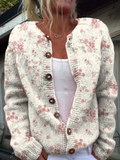 Cream knit cardigan with a small pink rose print and wooden buttons, worn open