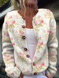 Cream knit cardigan with pink rose print and brown buttons, worn open over a white top