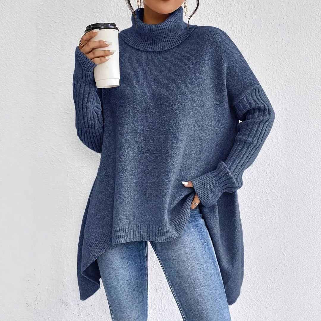 Blue oversized longline turtleneck sweater with ribbed sleeves and side slit, worn with jeans
