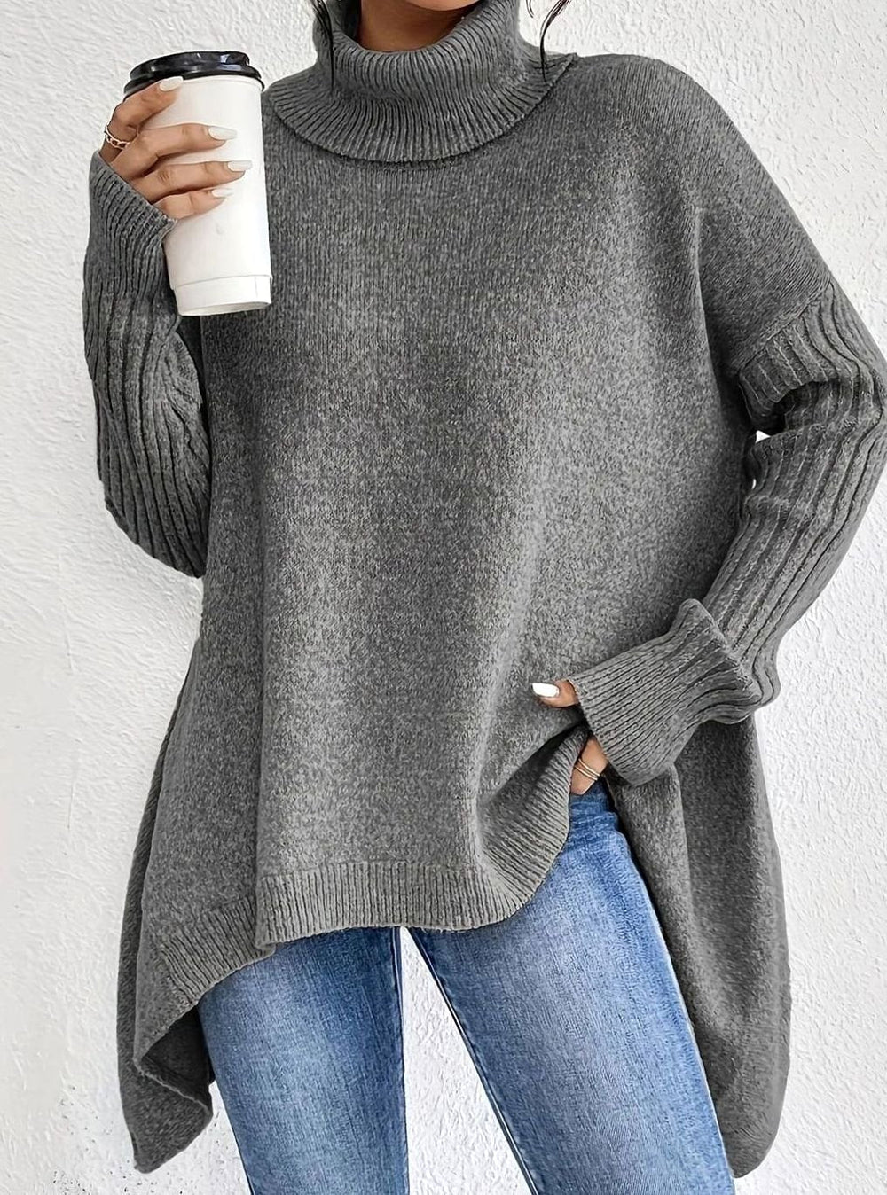 Grey oversized longline turtleneck sweater worn loose over blue jeans