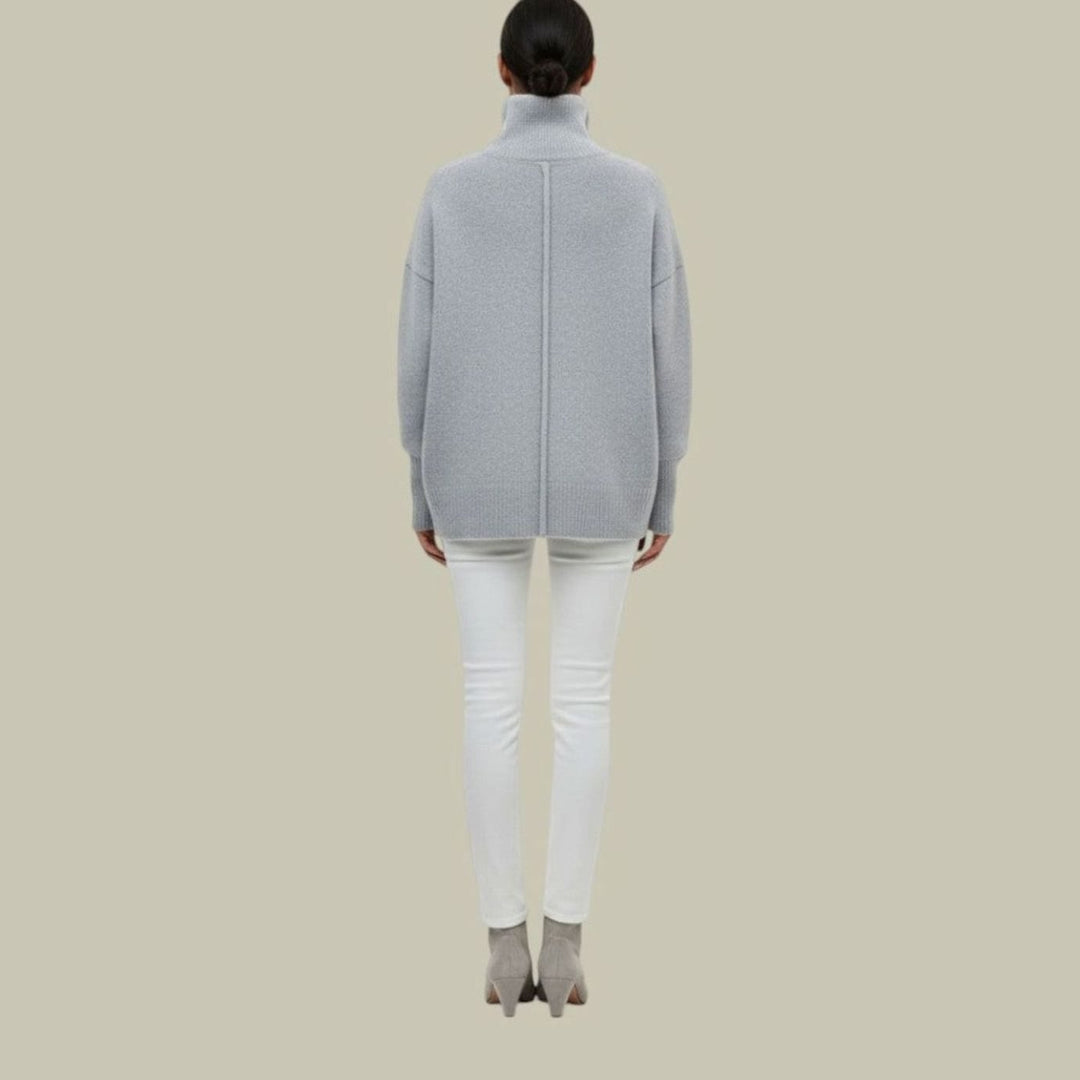 Back view of a light gray oversized turtleneck sweater with white jeans