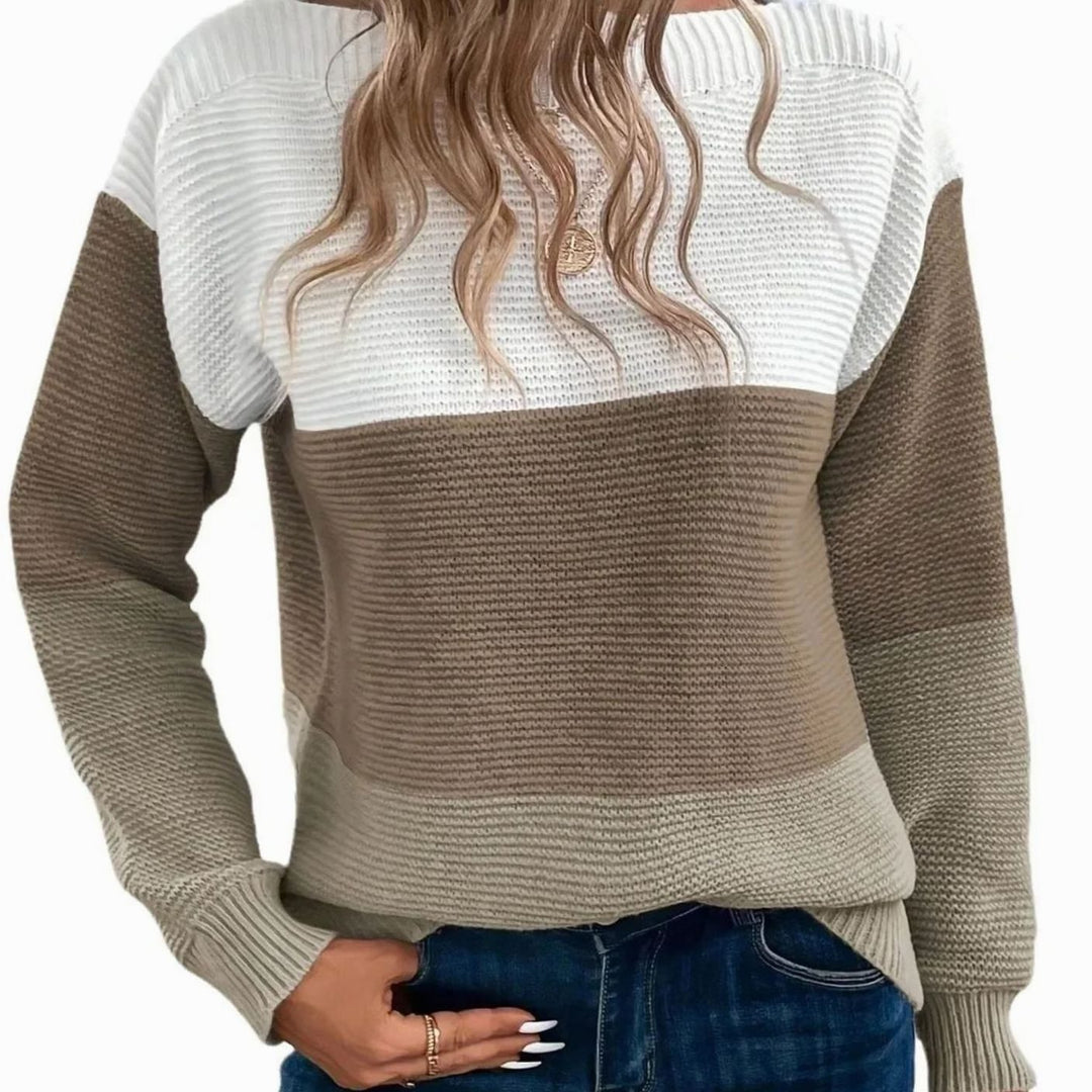 Model wearing a color block knit sweater in white, brown and beige with ribbed cuffs