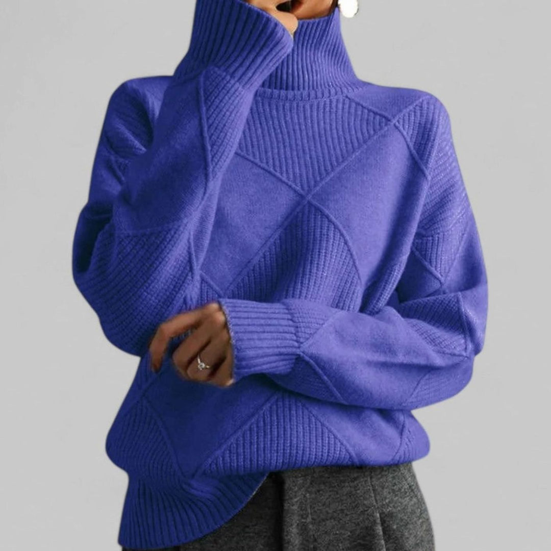 Purple oversized turtleneck sweater with a diamond knit pattern, worn with grey trousers