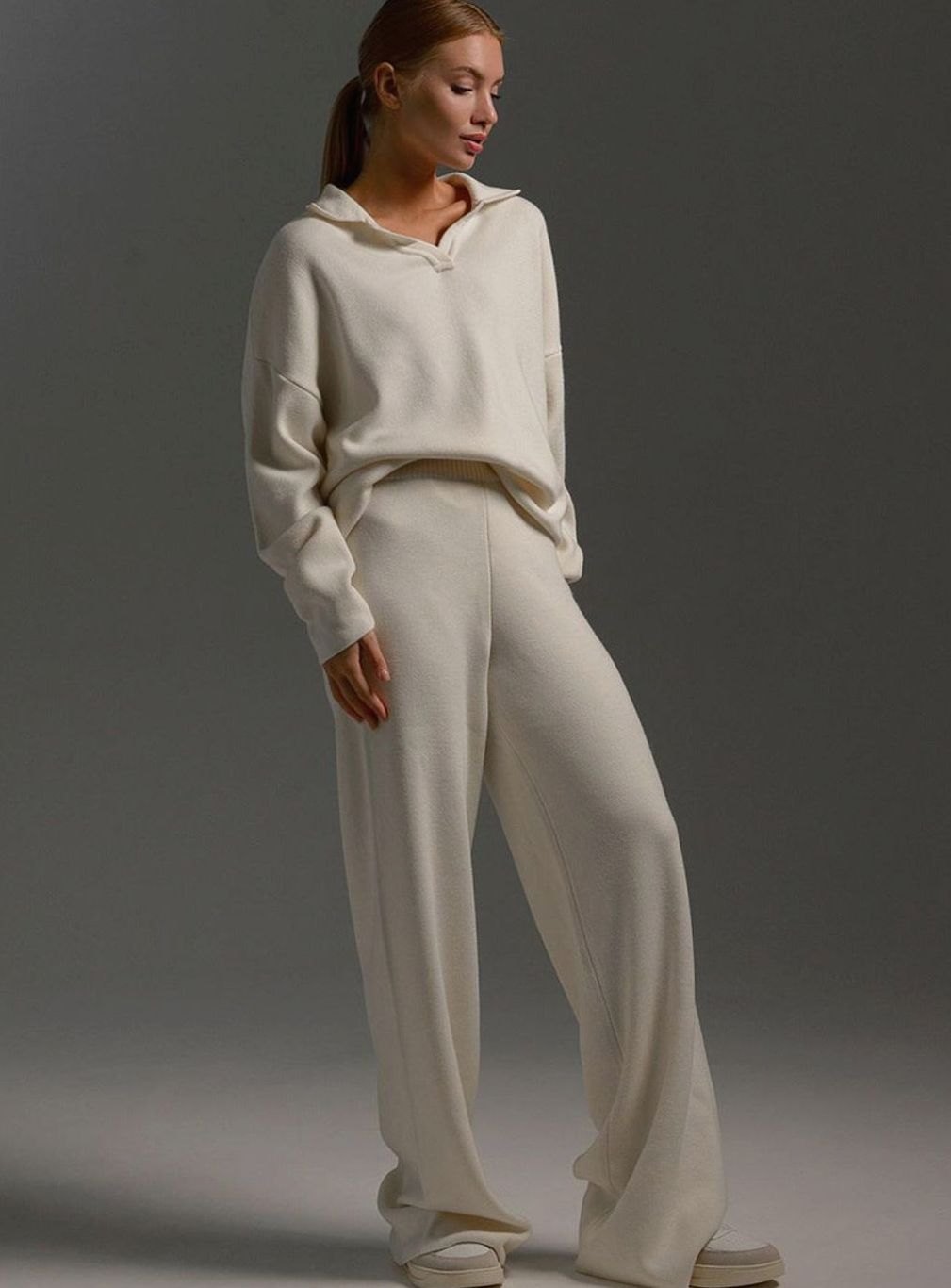 Model in a cream collared knit top with matching wide leg trousers