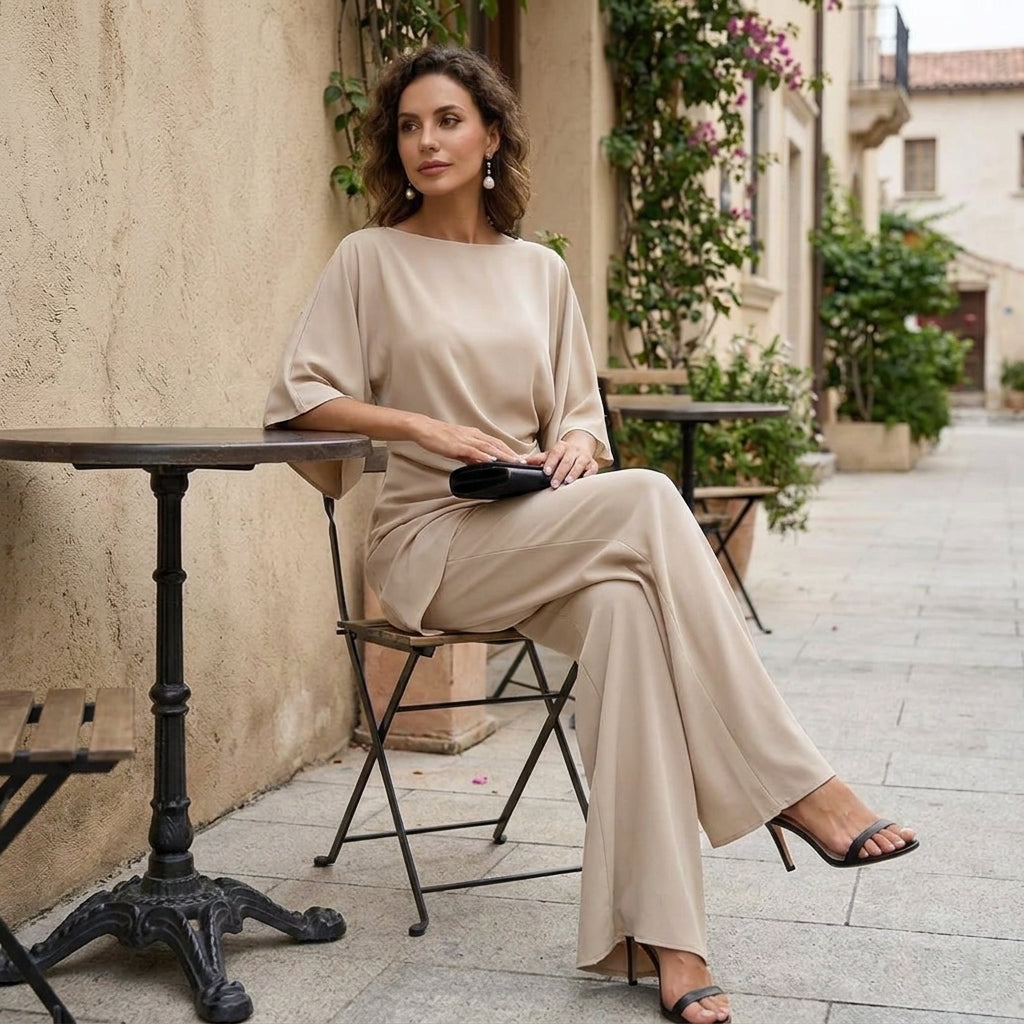 Beige draped cape sleeve set worn seated at a cafe table