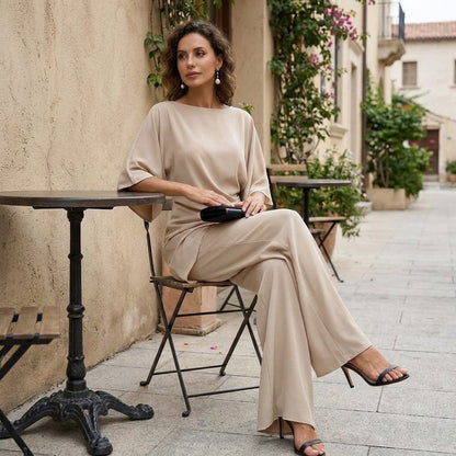 Beige draped cape sleeve set worn seated at a cafe table
