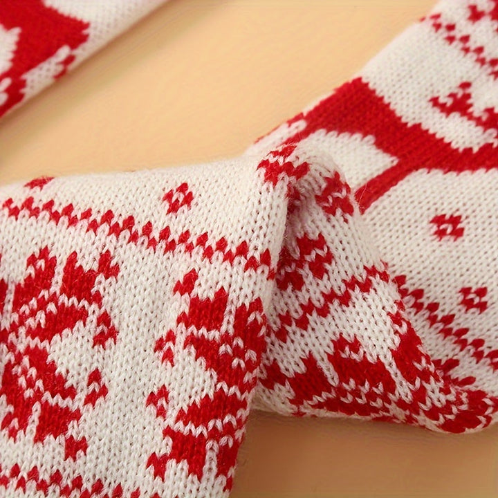 Close up of cream knit socks showing the red snowflake and reindeer jacquard and ribbed texture