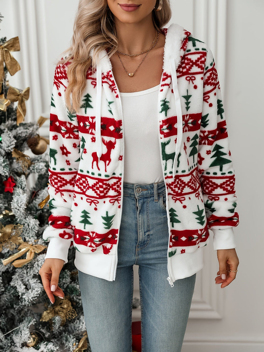 White fleece hooded jacket with red and green reindeer and tree pattern, worn open over a tank top