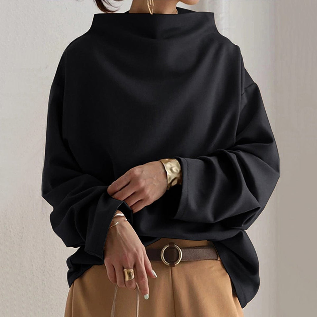 Black funnel neck dolman top worn with camel wide pants, front view