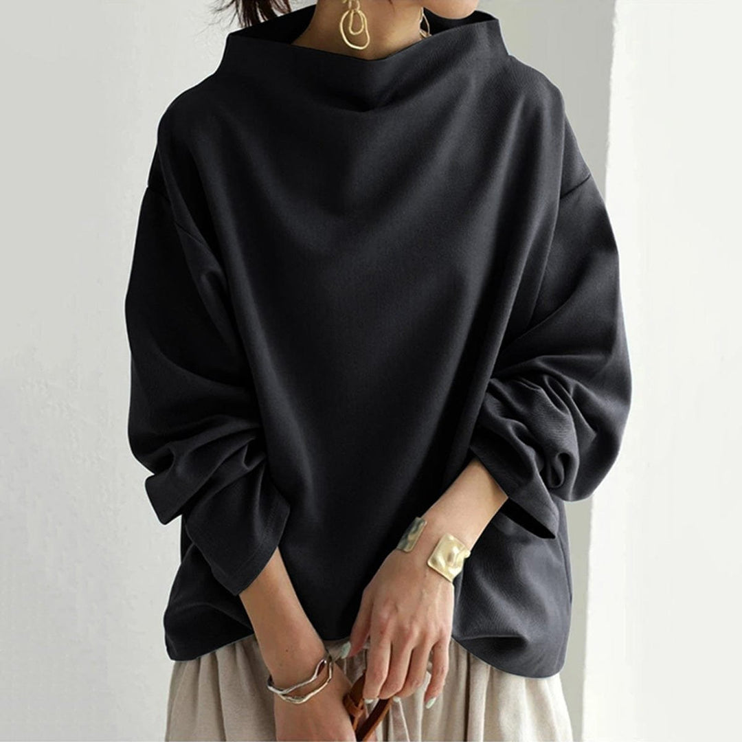 Black funnel neck dolman top over cream wide pants, front view