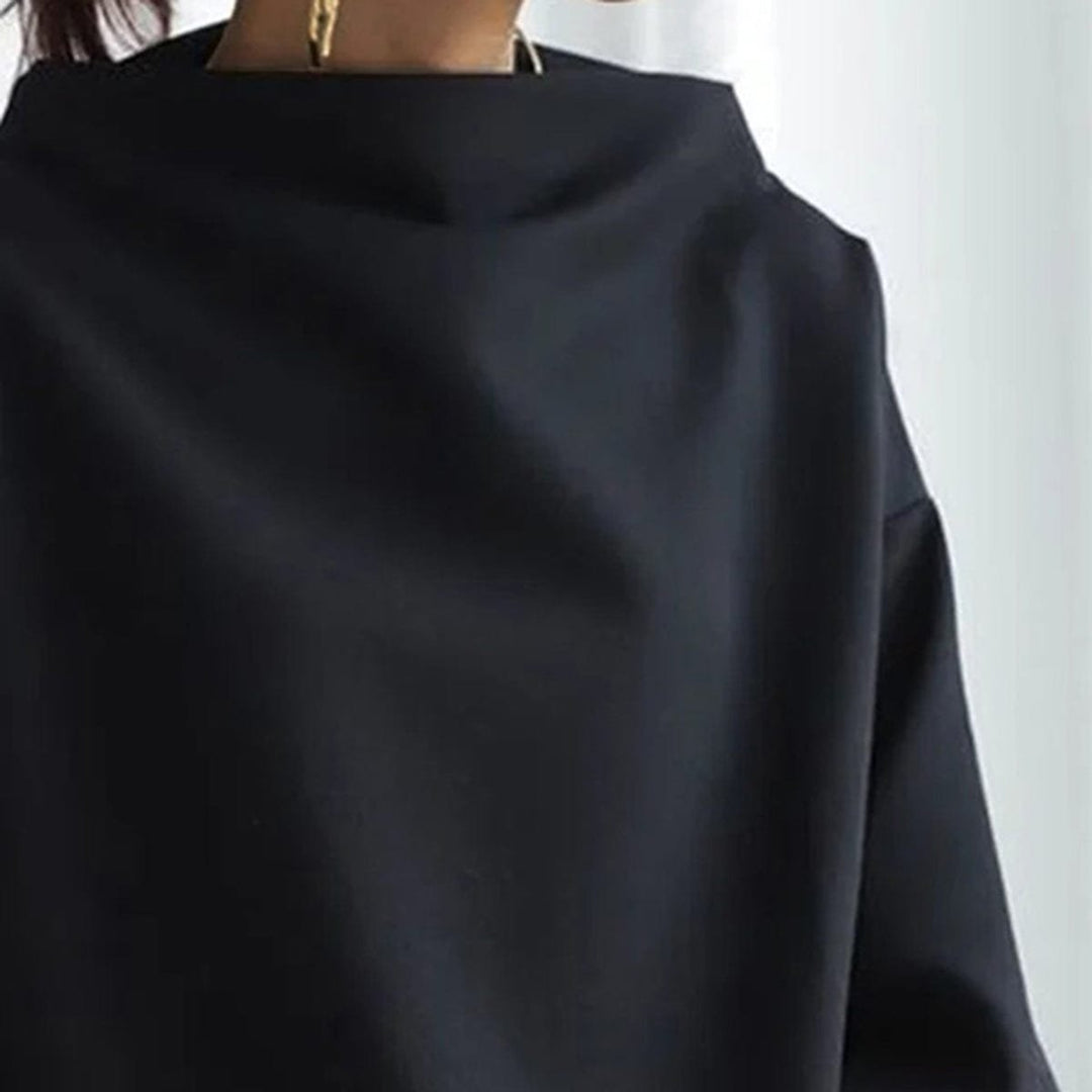 Close view of the standing funnel neck on the black dolman top