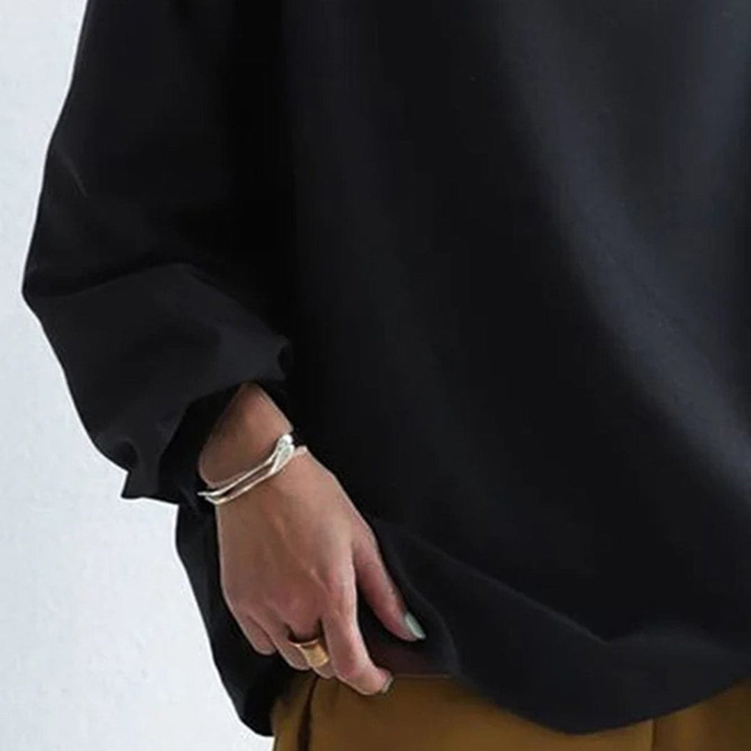 Close view of the sleeve end and hem on the black dolman top