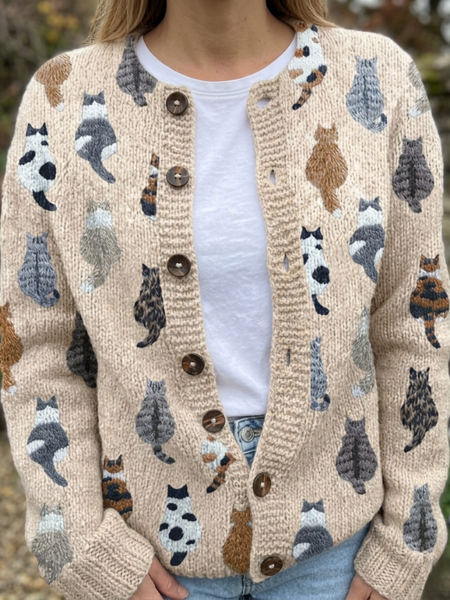 Cream knit cardigan with cat motifs all over, button front worn over a white tee
