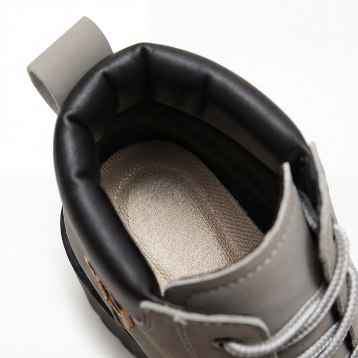 Close up inside the padded collar and gray lining of a lace up combat boot