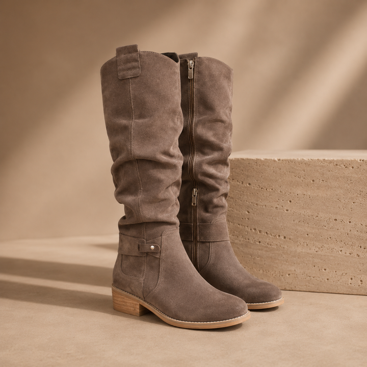 Grey suede knee high boots with a slouched shaft and side zip