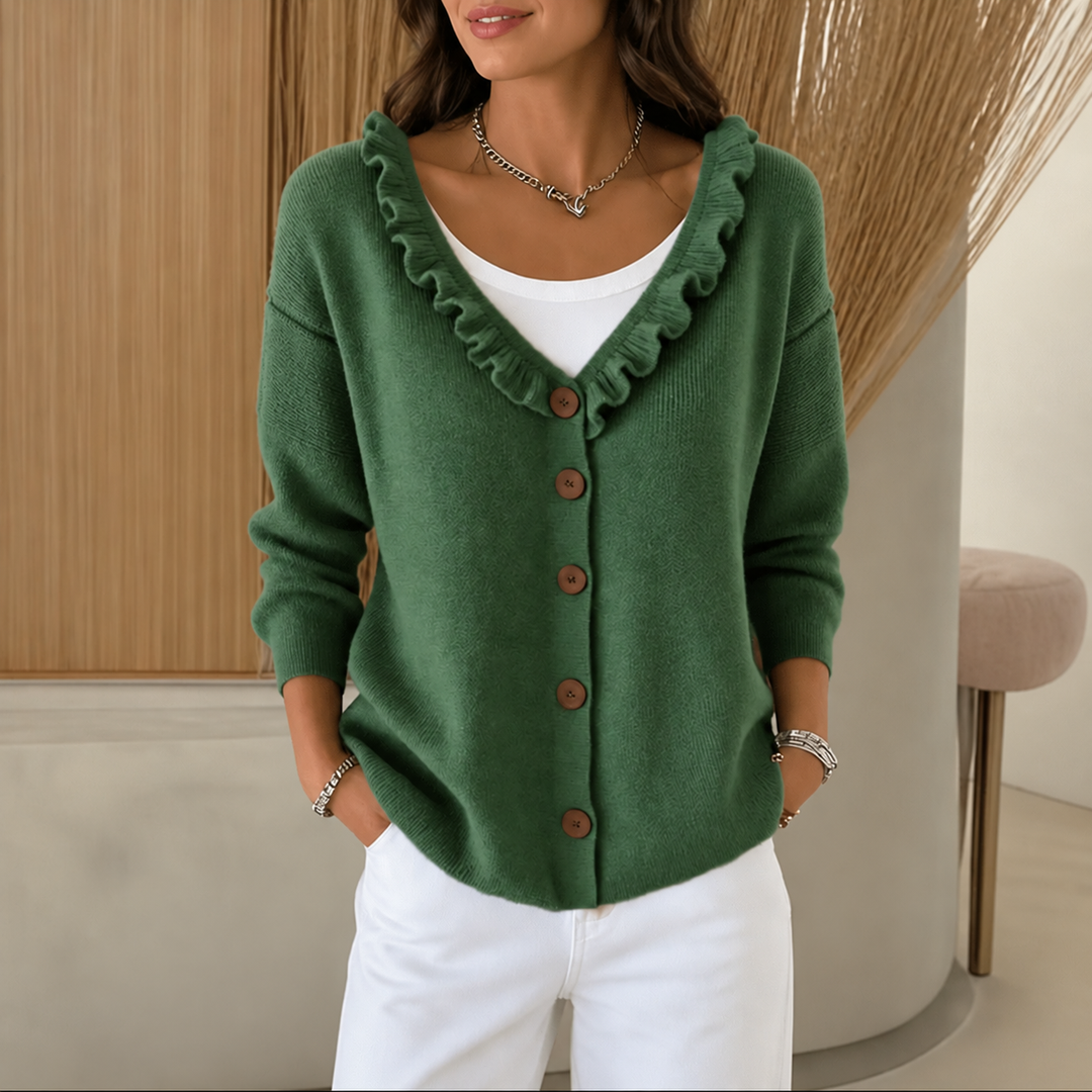 Green ruffle trim knit cardigan with wooden buttons styled with white trousers