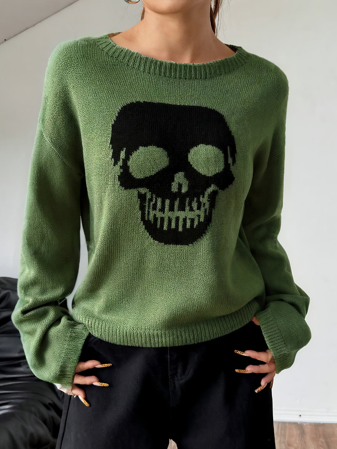 Green crew neck knit sweater with a large black skull graphic on the front