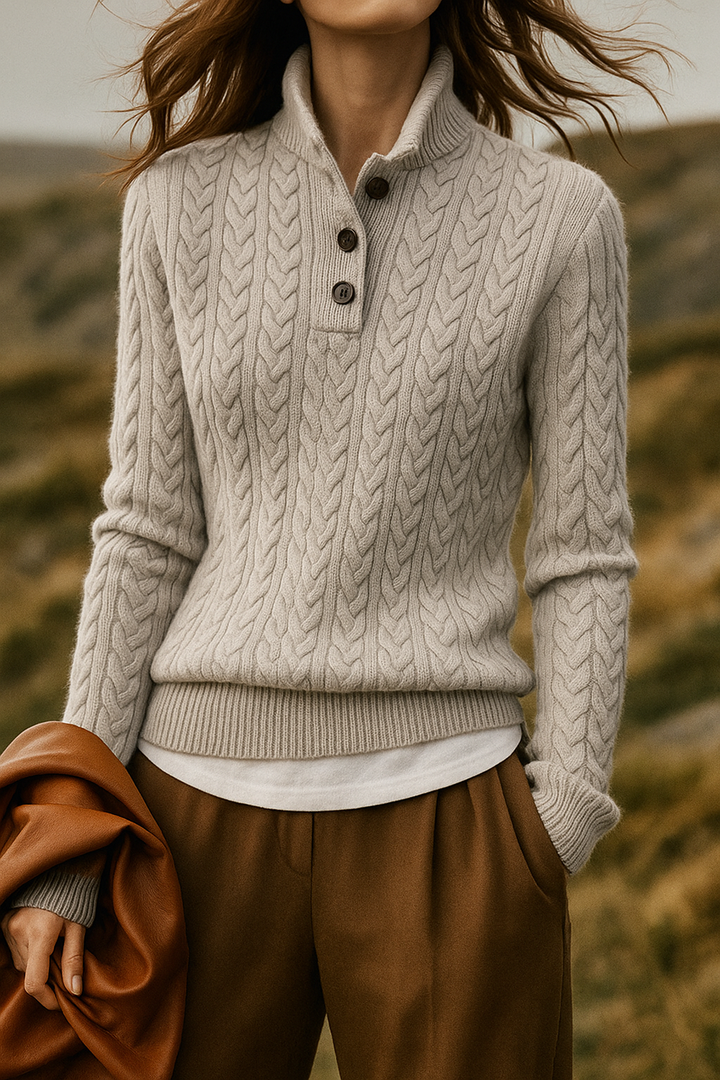 Grey cable knit sweater with a stand collar, worn over a white shirt outdoors