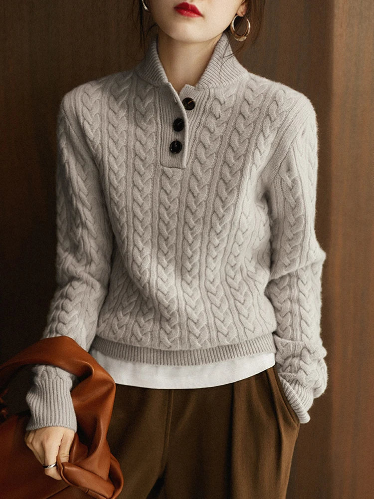 Grey cable knit sweater with a stand collar, worn with the placket unbuttoned