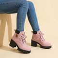 Pink lace-up platform ankle boots with black lug soles worn with jeans