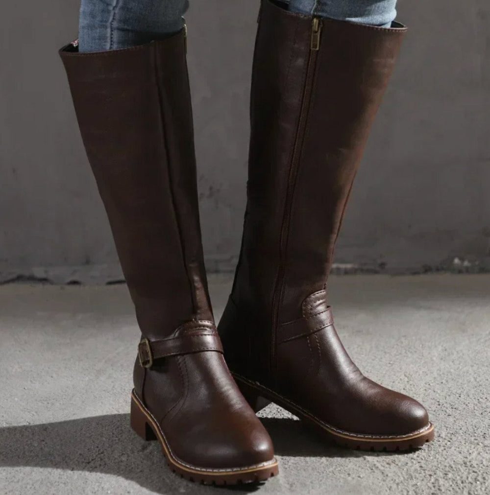 Dark brown knee high riding boots with a buckle strap and low block heel
