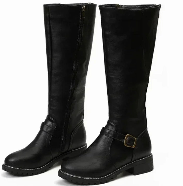 Pair of black knee high leather boots with ankle buckle strap and lug sole