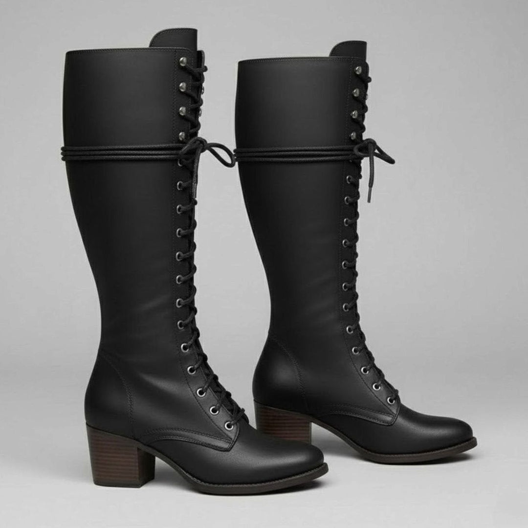 Pair of black lace up knee high boots with a stacked block heel and studded shaft