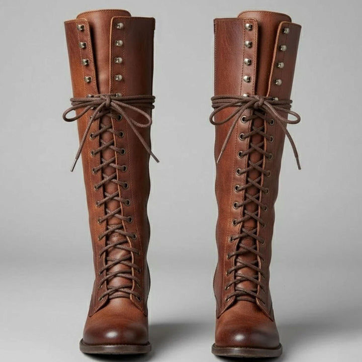 Pair of brown leather lace up knee high boots with studded shafts, front view