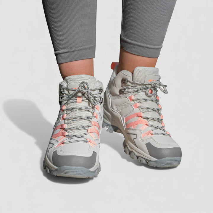 Grey and pink lace up hiking shoes with rugged non slip soles, worn with grey leggings, front view
