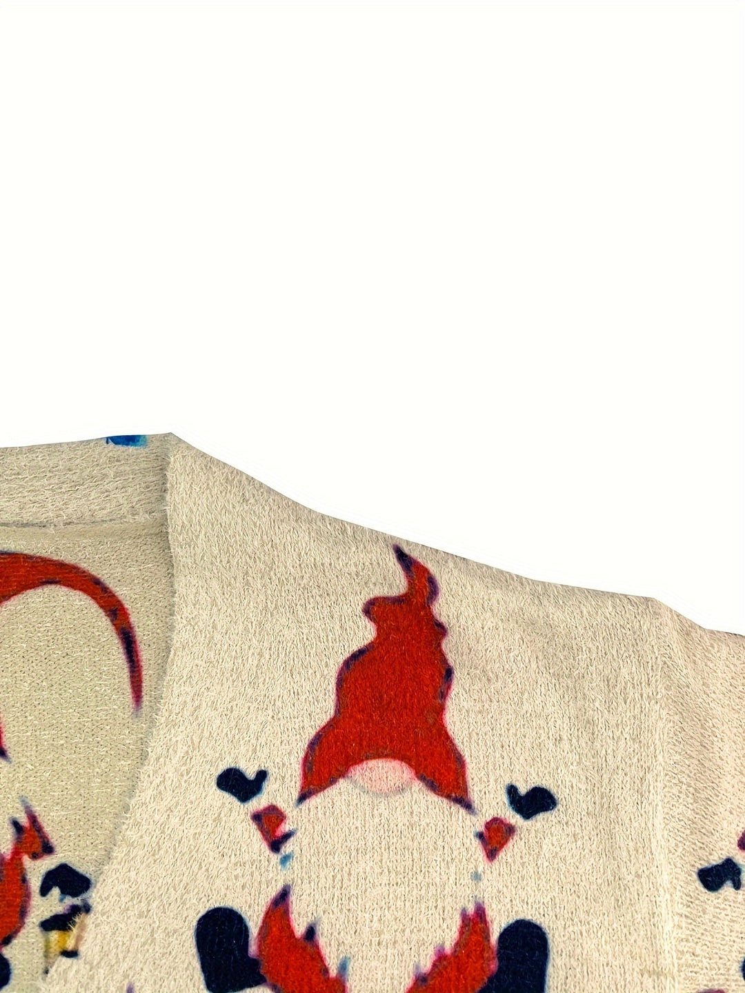 Close up of a cream knit cardigan with a red gnome print and V neckline
