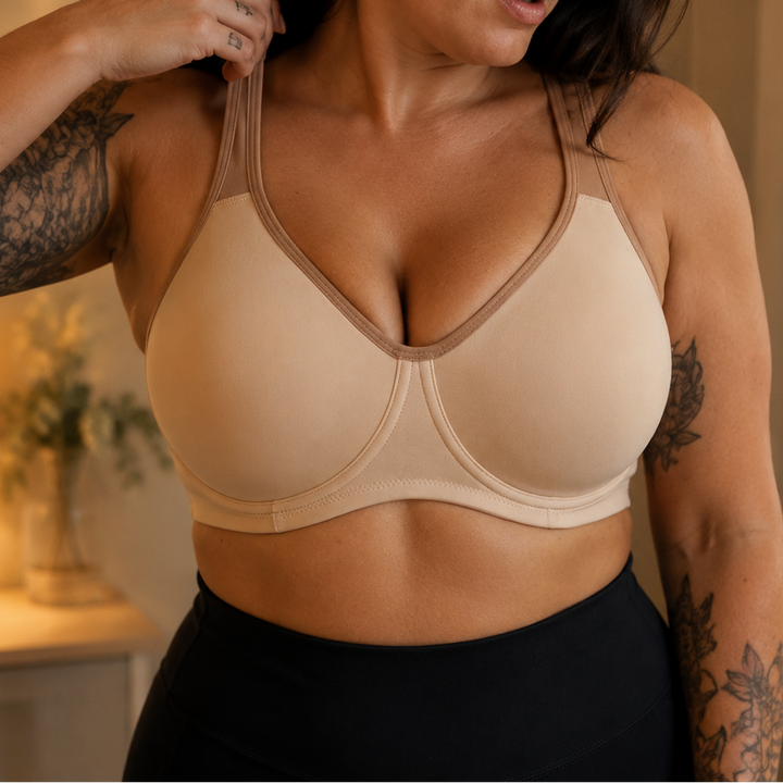 Woman adjusting the strap of a nude full-bust sports bra