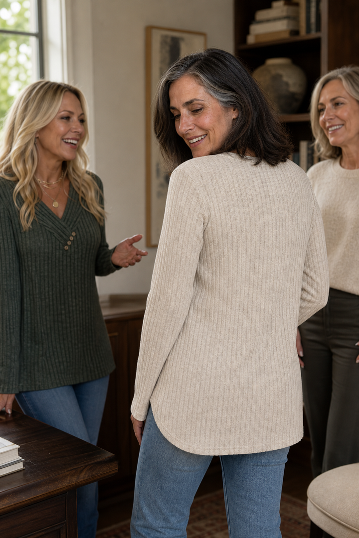 Back view of the oatmeal ribbed knit top with a curved hem, worn with jeans