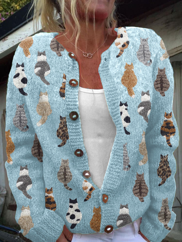 Light blue knit cardigan with embroidered cat motifs and brown buttons, front view