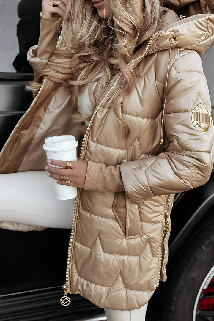 Beige glossy longline puffer coat worn open over a cream knit, front view