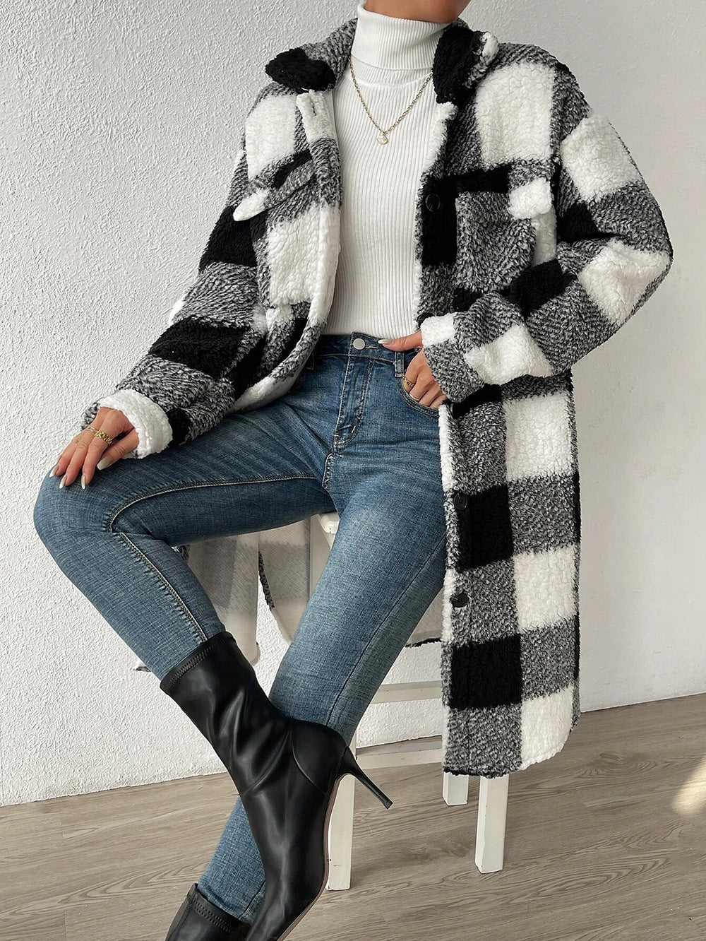 Black and white teddy check coat worn open, seated front view