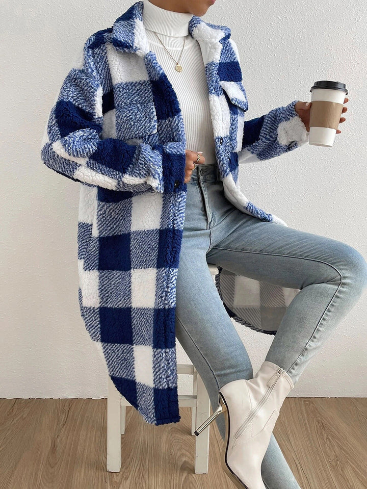 Navy and white teddy check coat with blue jeans, seated front view