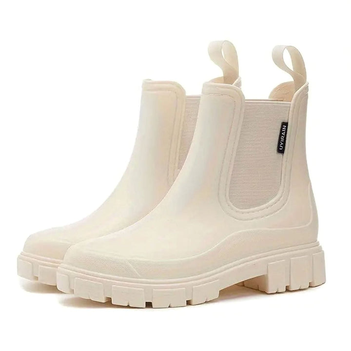 Pair of cream waterproof Chelsea rain boots with chunky lug soles and elastic side panels