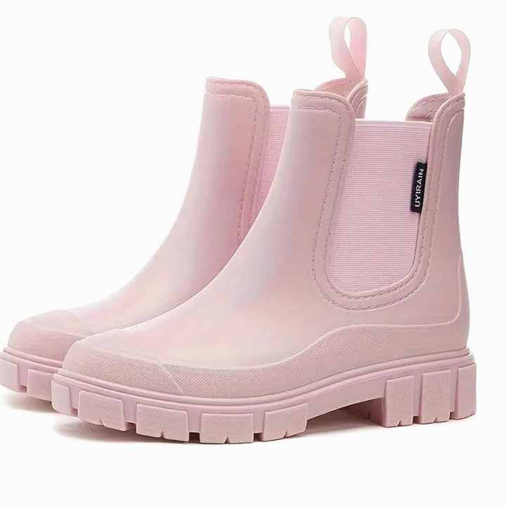 Pair of pale pink chelsea rain boots with elastic side panels and a chunky lug sole
