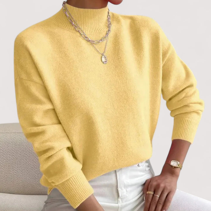 Pale yellow loose fit knit sweater with ribbed mock neck and cuffs