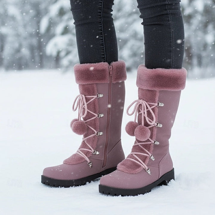 Mauve mid calf boots with a fur cuff and pom laces in the snow