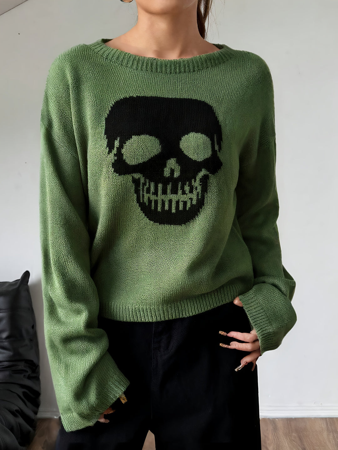 Olive green crew neck sweater with a large black skull knit on the front