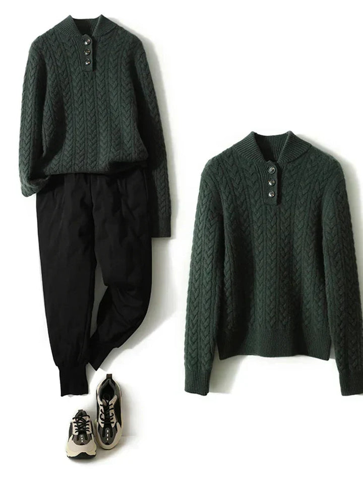 Olive green cable knit sweater with a stand collar, shown flat beside black pants