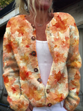 Knit cardigan printed with orange and cream autumn leaves, wooden buttons, worn open