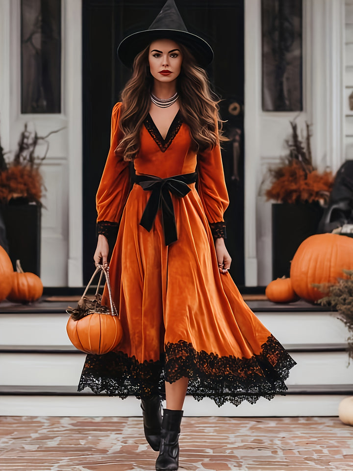 Burnt orange velvet midi dress with black lace hem and velvet sash, worn on a front porch