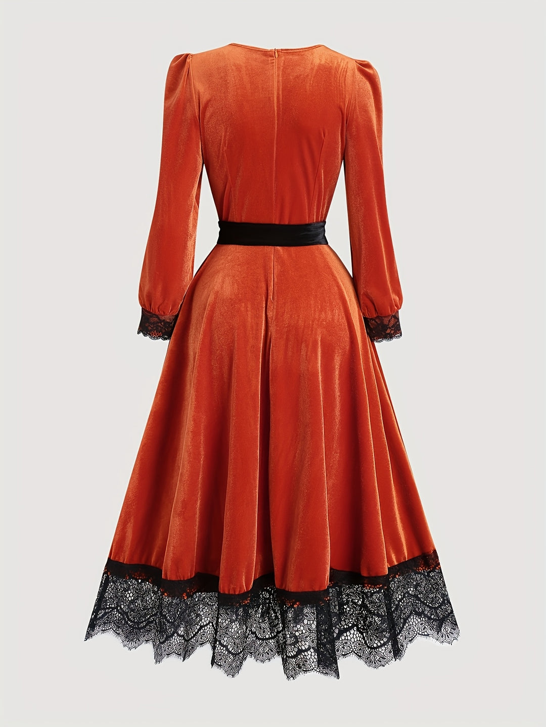 Back of a burnt orange velvet midi dress with a black lace hem and a black waist sash