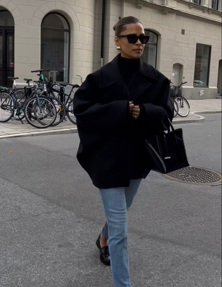 Black oversized cropped peacoat worn with jeans, walking front view