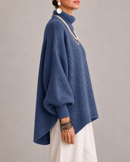 Blue oversized turtleneck sweater, side view showing the high-low hem