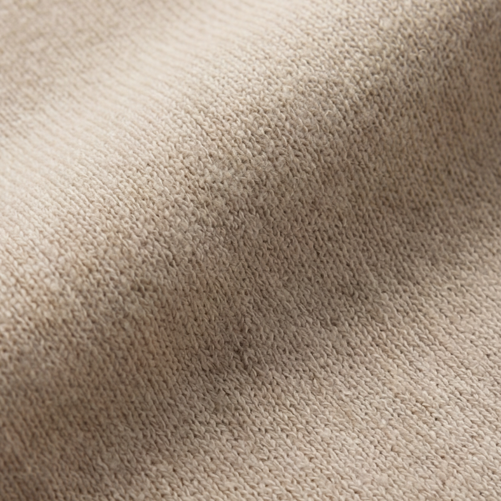 Close up of the beige wool blend knit fabric showing its soft texture